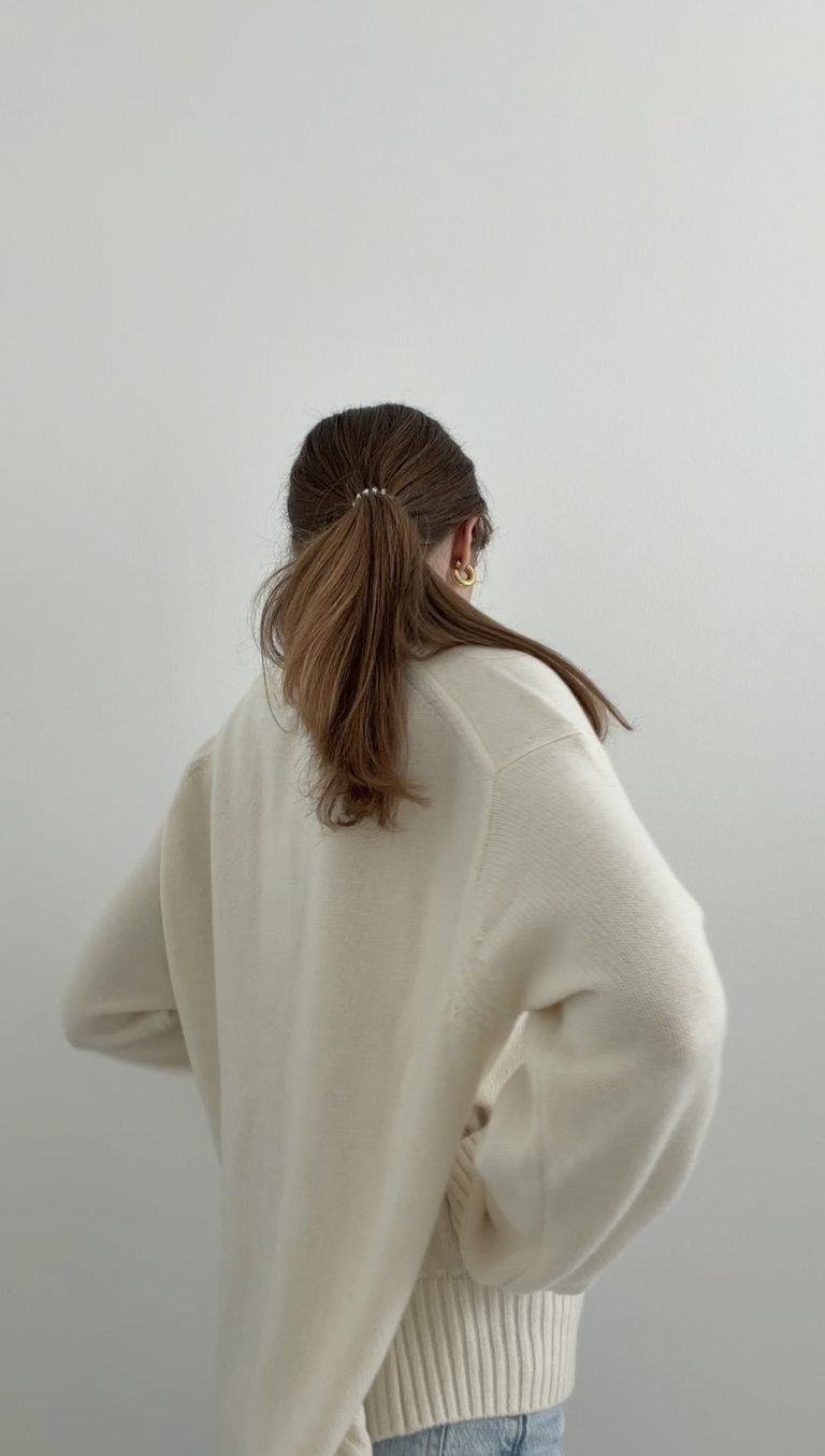 Model in cremefarbenem Wollpullover