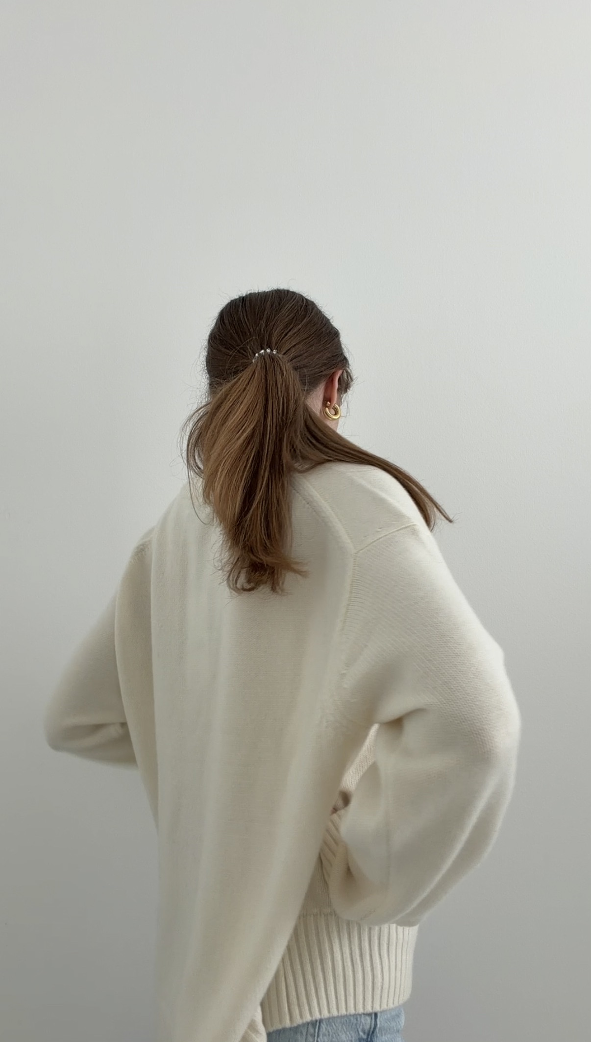 Model in cremefarbenem Wollpullover
